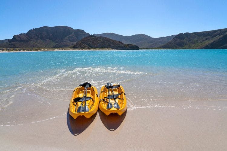 Two yellow kayaks on the white sand of Balandra Beach in La Paz