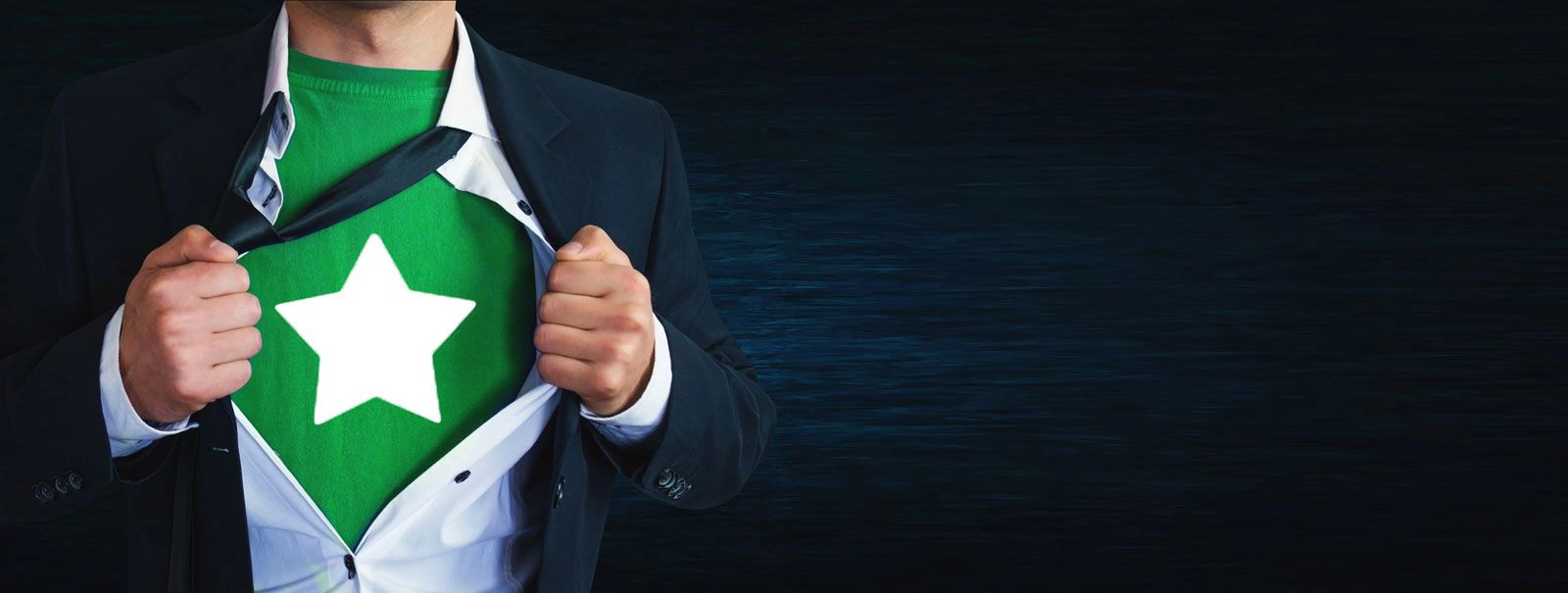 A man pulling open his business shirt to reveal a green superhero shirt underneath