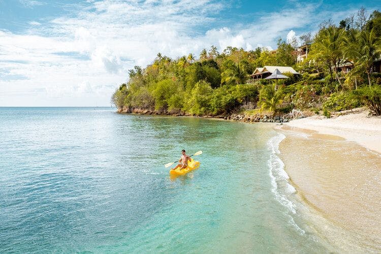 A man in a sea kayak relaxed by the seashore off St Lucia