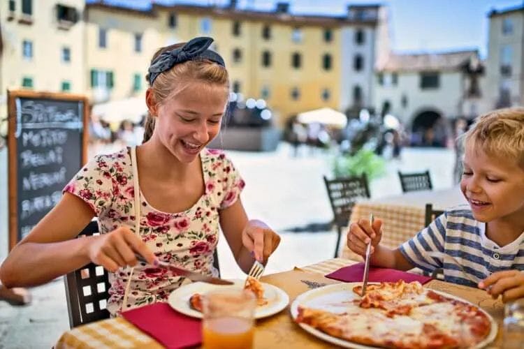 Two children enjoying pizza at an Italian restaurant
