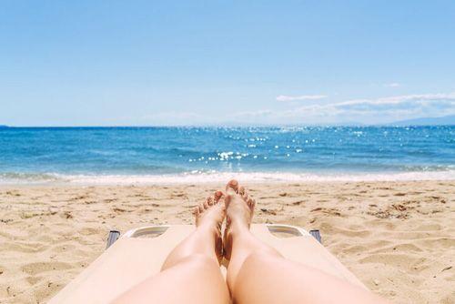 A woman lying on a golden sand beach