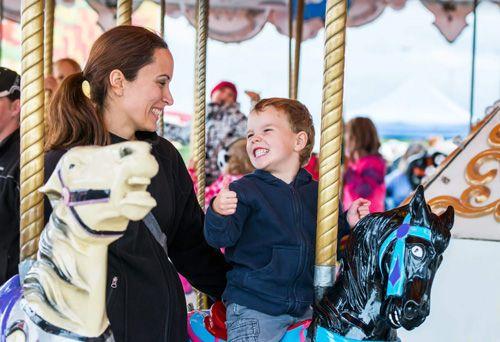 A young boy and a woman on a carousel