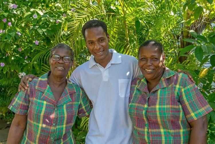 Three staff members in a Caribbean villa pose for a photo