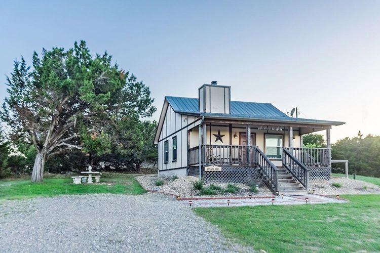 Charming cabin rentals in Fredericksburg, TX - Fredericksburg 31 small wooden cabin with porch and large tree in the garden