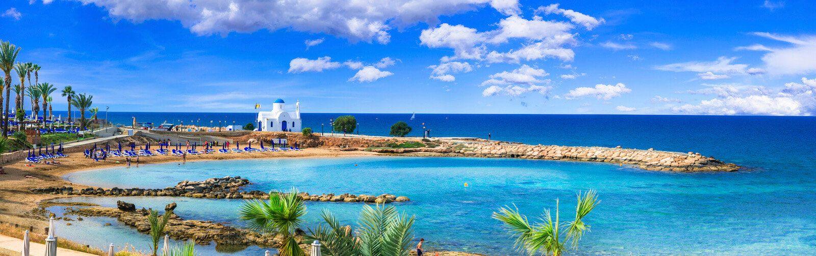 A white and blue domed church on a jetty in Cyprus
