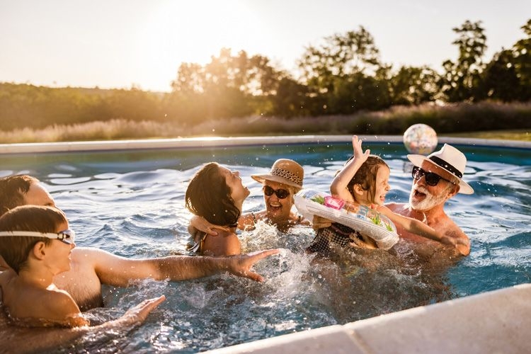 A multigenerational family laughing and smiling in a swimming pool