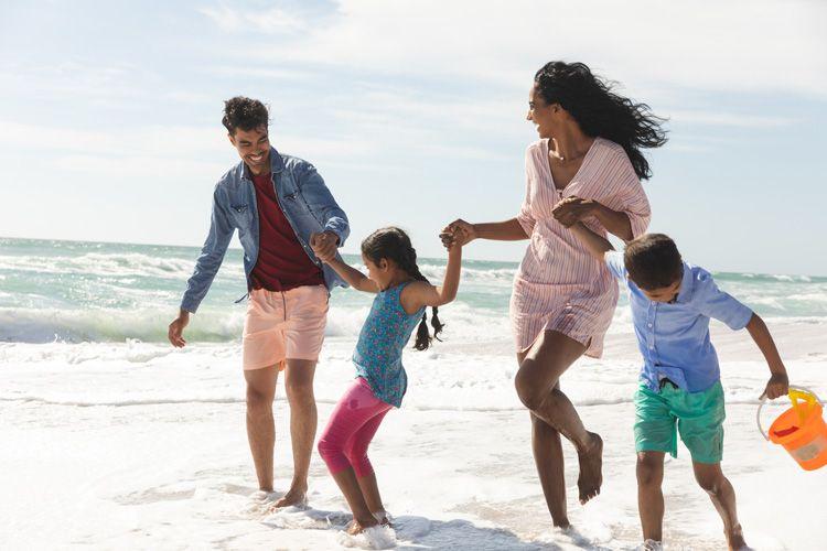 A family f four playing in the surf on a golden sand beach