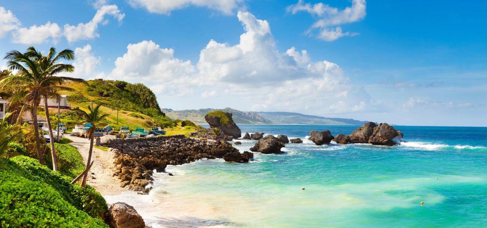 Glitter Beach view with sea rocks, palm trees, and shallow water