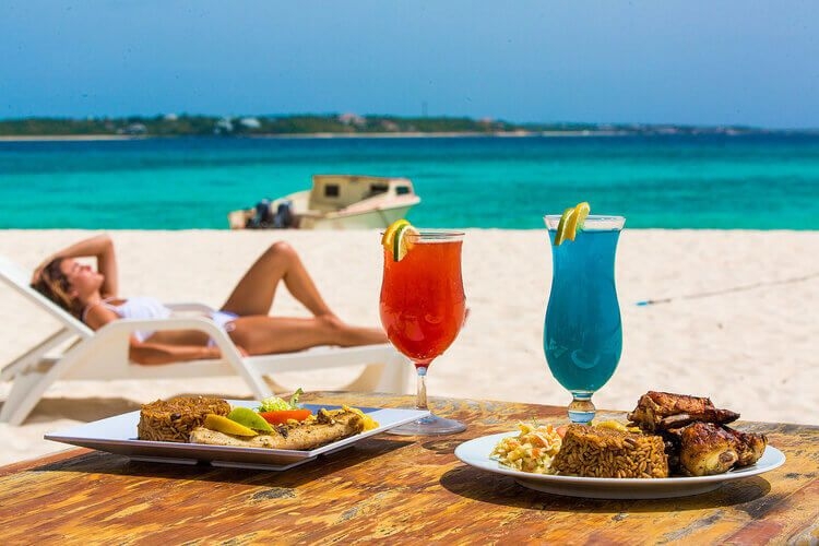 A vacation guest enjoys a private chef experience on the beach