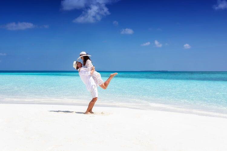 A couple on a white sandy beach enjoying our romantic Turks and Caicos honeymoon villas