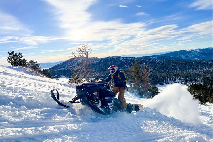Snowmobile heading up a mountain overlooking Lake Tahoe