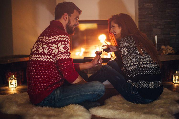 A couple sit in front of a roaring fire. Romantic cabins in Nevada.