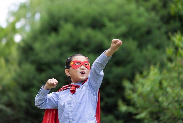A young girl in a superhero costume