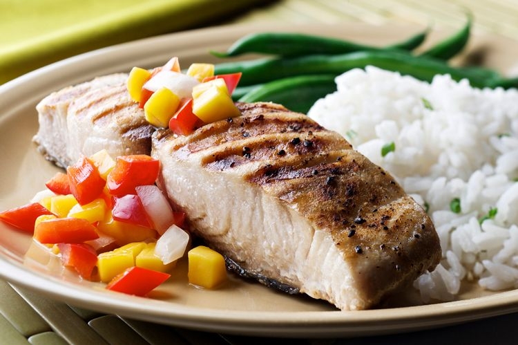 Grilled mahi mahi steak with fruit relish, rice, and beans
