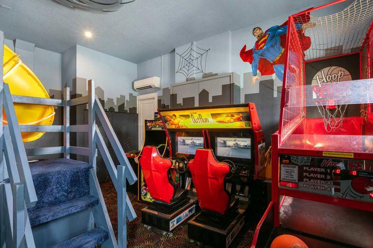 Reunion Resort 9000 vacation rental games room with arcade machines and indoor basketball game and superman painted on the wall