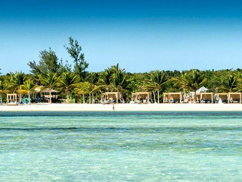 White sand beach with wooden cabana sunbeds on the sand