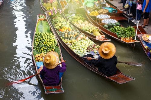 Floating market in Thailand with boats full of fruit and spices