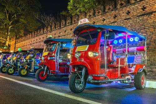 Tuk tuks parked up by an old wall