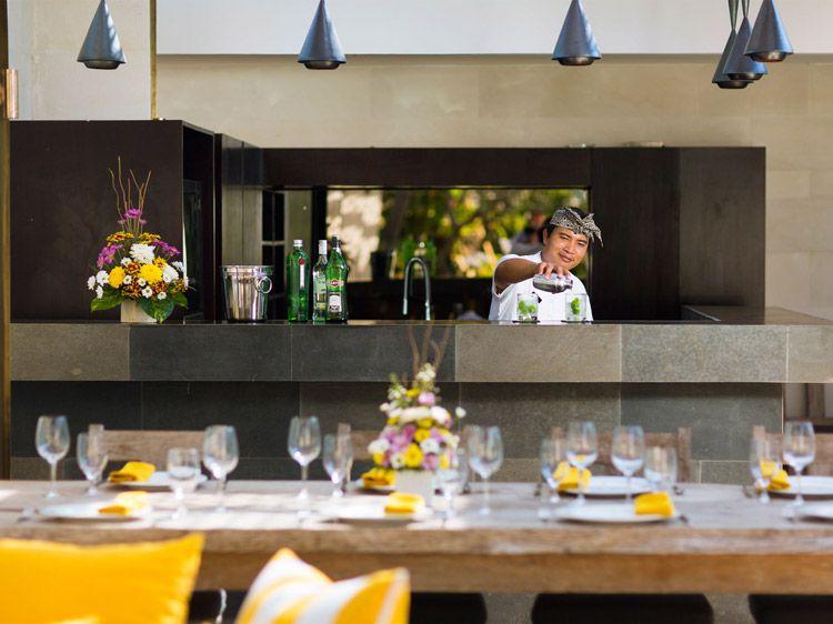 A bar tender prepares cocktails in a villa's private bar