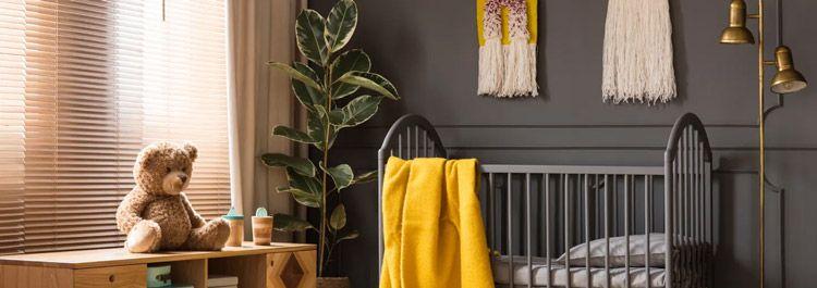 A room set up for a baby, with a crib, teddy bear, and blanket
