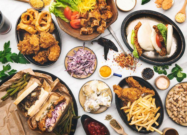 A table of assorted USA food, including fired chicken, potato salad, and buns
