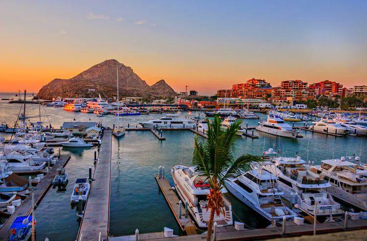 Cabo harbor with yachts and El Arco rock formation in the background
