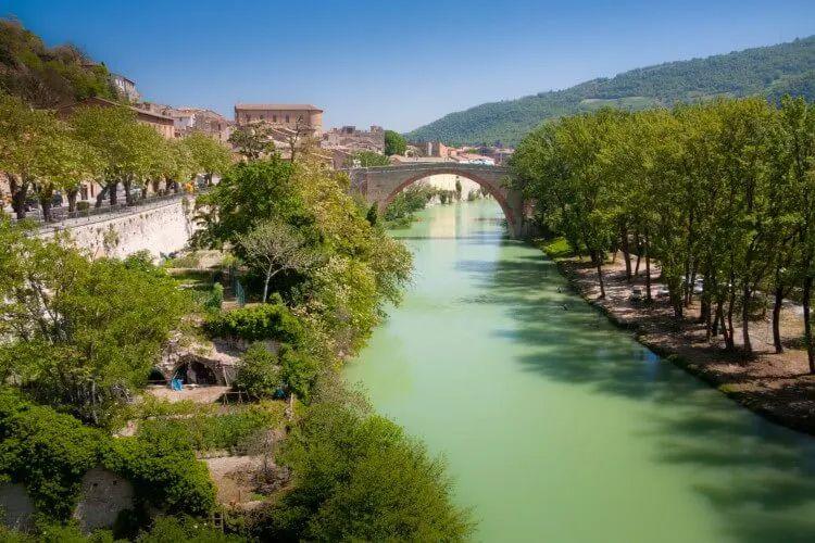 River with stone arch bridge over it