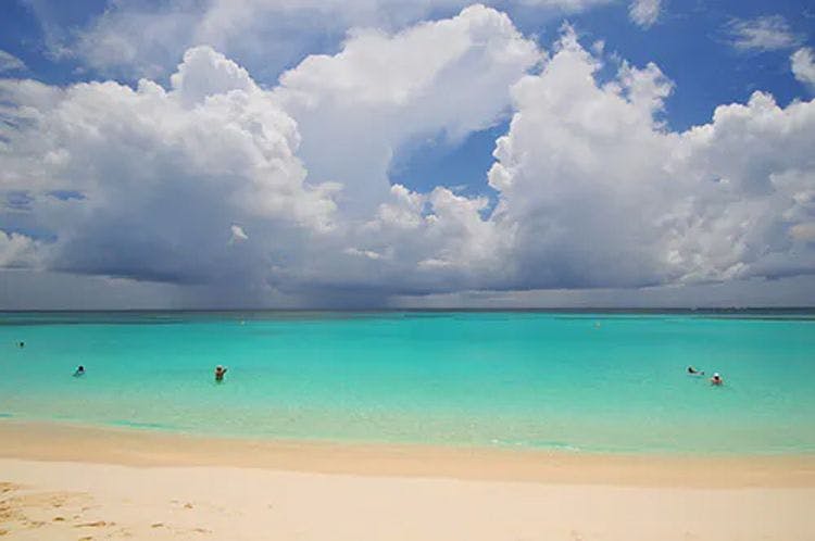 Turquoise sea with cloudy sky and white sand beach