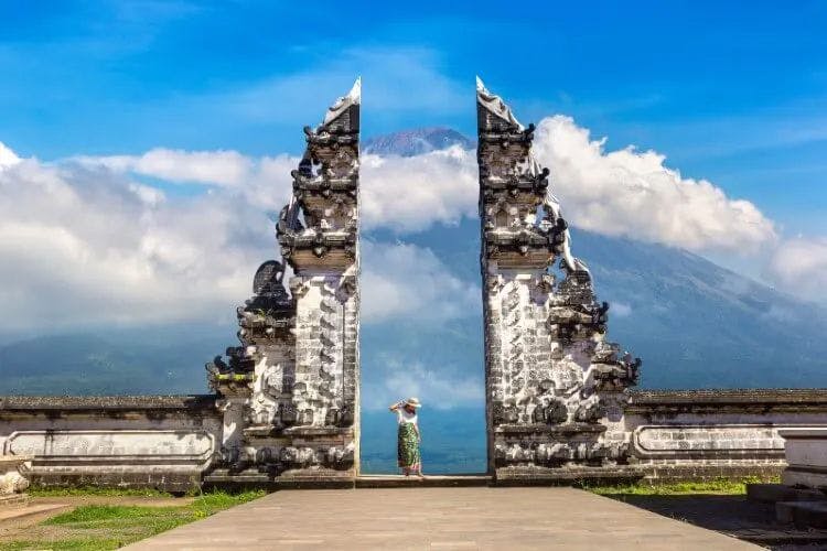 A woman stands at the entrance to a temple on a Bali mountain