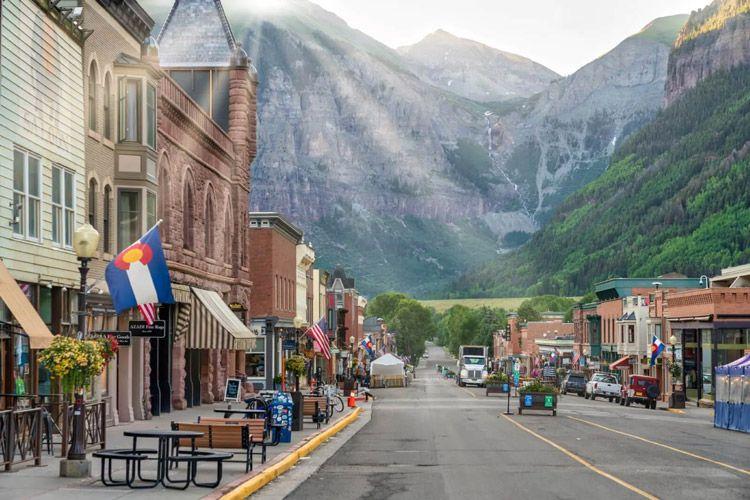 A sunlit street with mountain backdrop in Colorado
