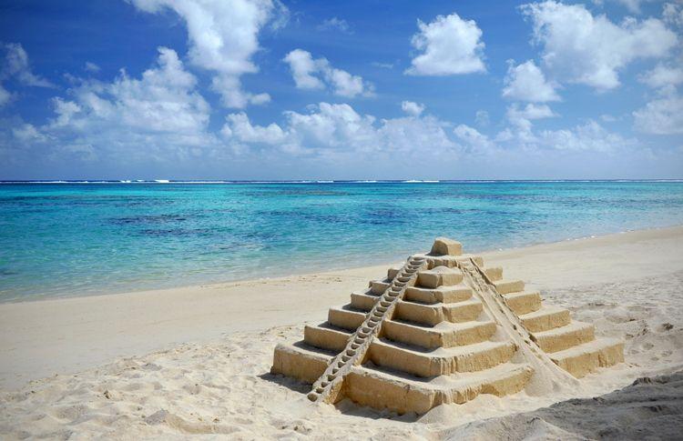 A sandcastle of Chitchen Itza on a white sand beach