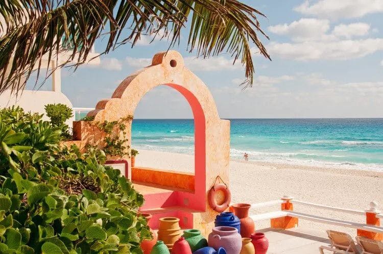 Cancun beach with stone archway and colorful pots