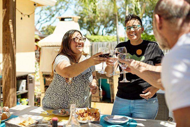 A group of friends clinking wine glasses over a table full of food
