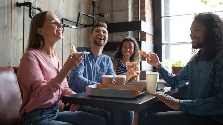 A group of people sit around a table in a restaurant