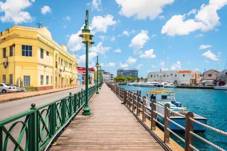 A boardwalk along the sea with a yellow building to the right