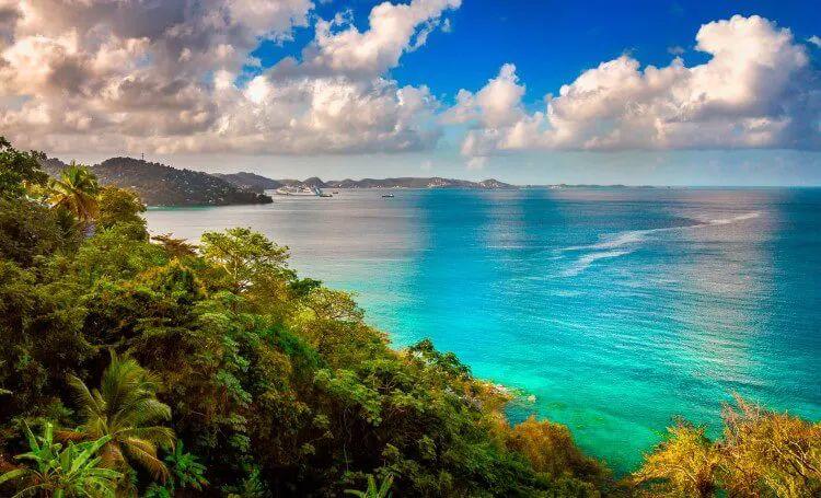 Grenada coastline with dense verdant forests by turquoise sea
