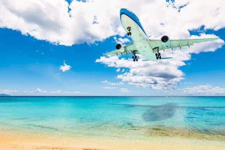 A plane coming into land at an airport by a beach