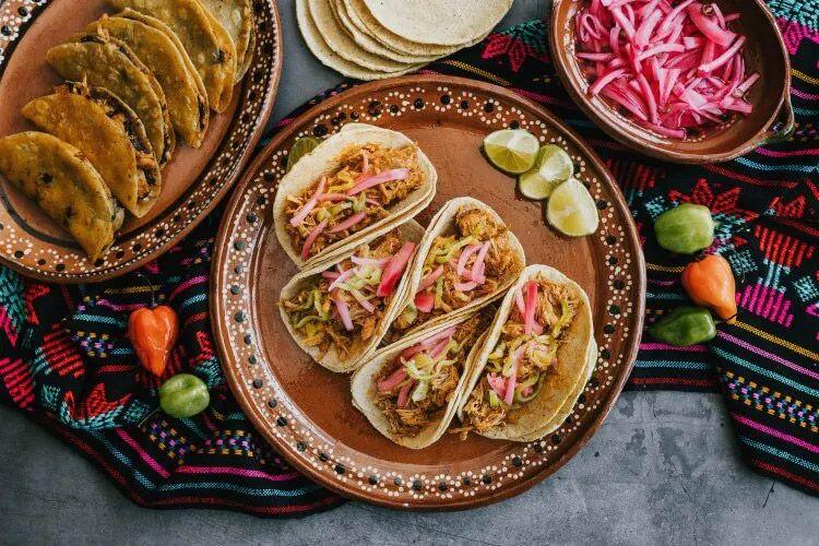 A plate of four soft tacos and hard shell tacos and salad items