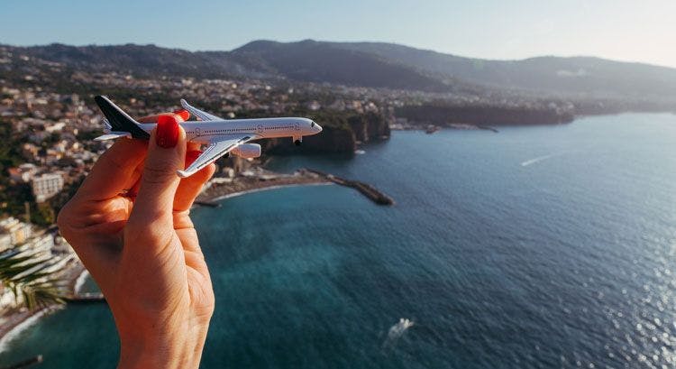 A person holding a toy plane against the backdrop of Sorrento city