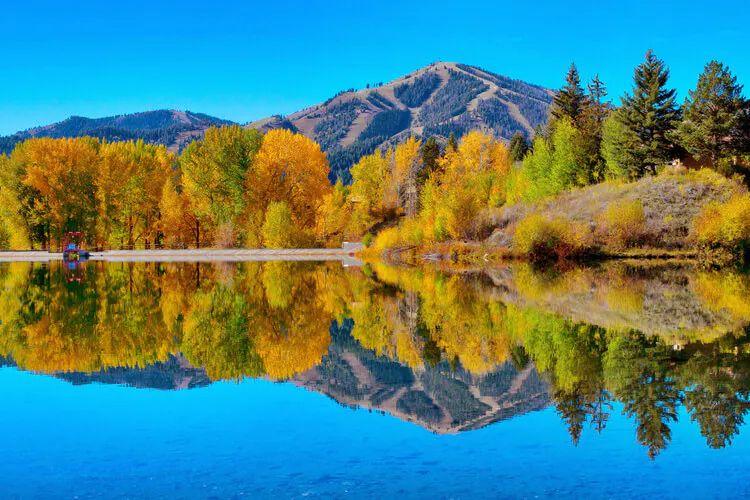 Sun Valley fall landscape with mountains and trees reflected in still lake