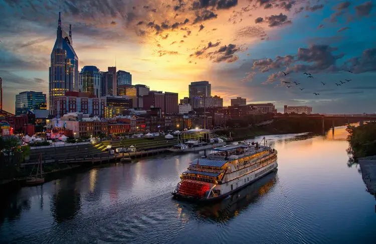 Sunset over Downtown Nashville with riverboat sailing by