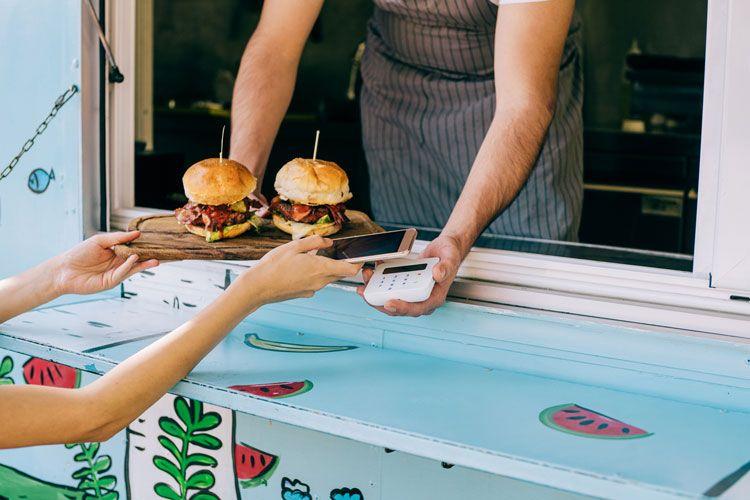 A person buying burgers from a food truck