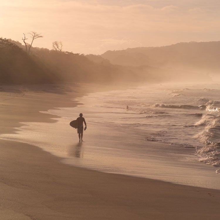 A person walking along a misty beach in Costa Rica - Best places to visit in January