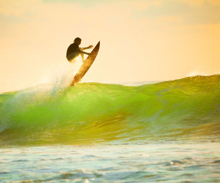 A person on a surfboard jumping off the crest of a wave in Bali