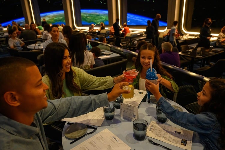 Disney World restaurants. A family enjoy a fun and immersive meal at EPCOT Disney.